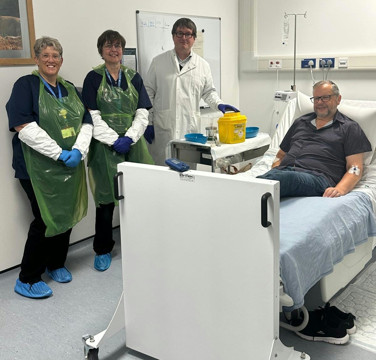 A doctor and two nurses standing next to a patient's bed